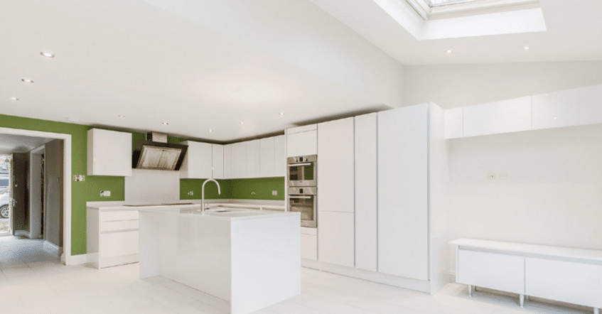 South London Modern white kitchen with green accent wall and minimalist design